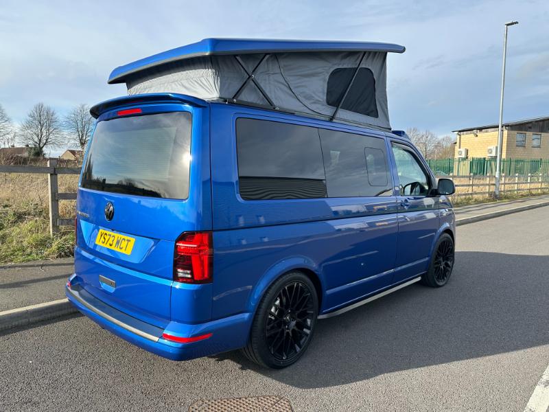 Blue T6 transporter Campervan with grey pop top raised.